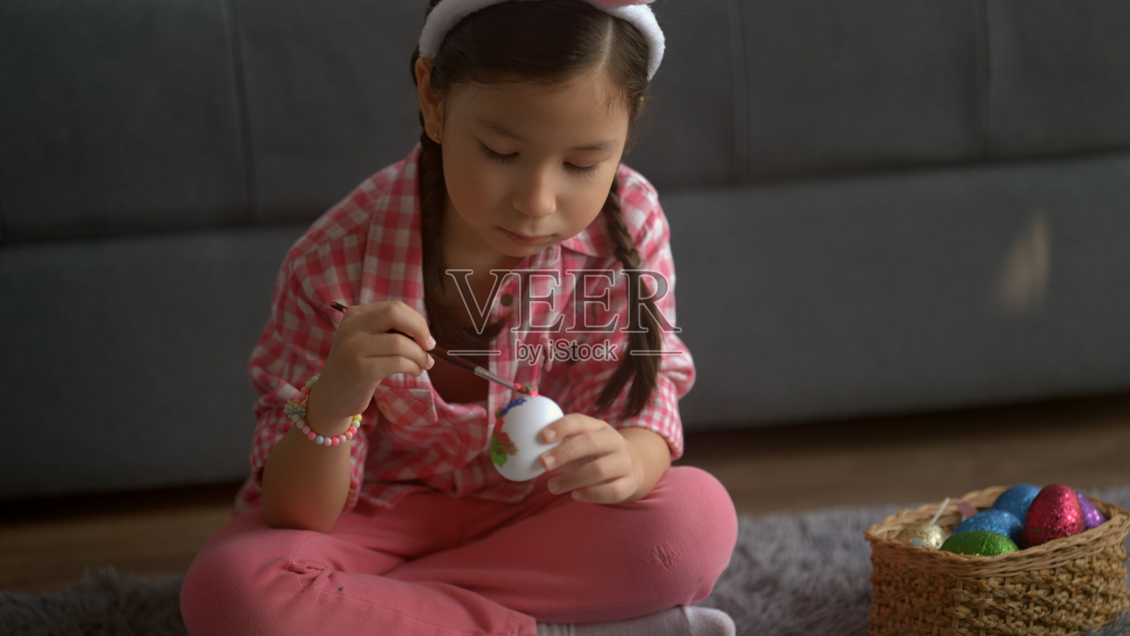小女孩坐着画复活节彩蛋照片摄影图片