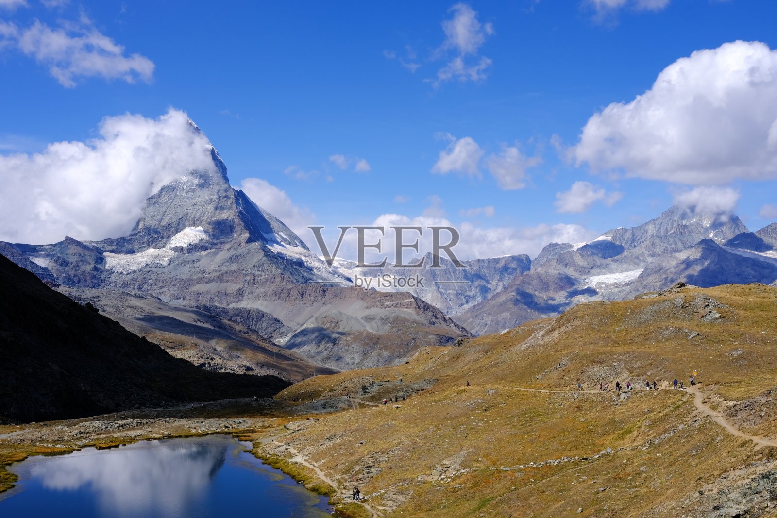 白云覆盖下的马特洪峰映在里菲湖上。照片摄影图片