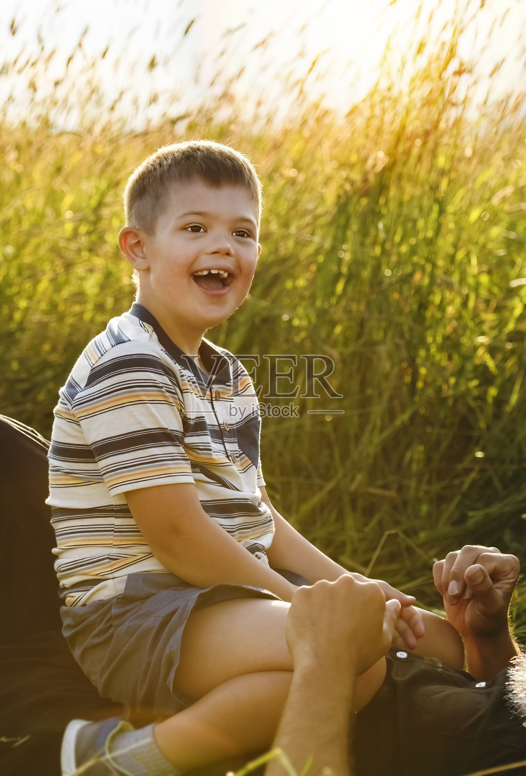 夏季日落时分，患有唐氏综合征的小男孩和父亲的肖像照片摄影图片