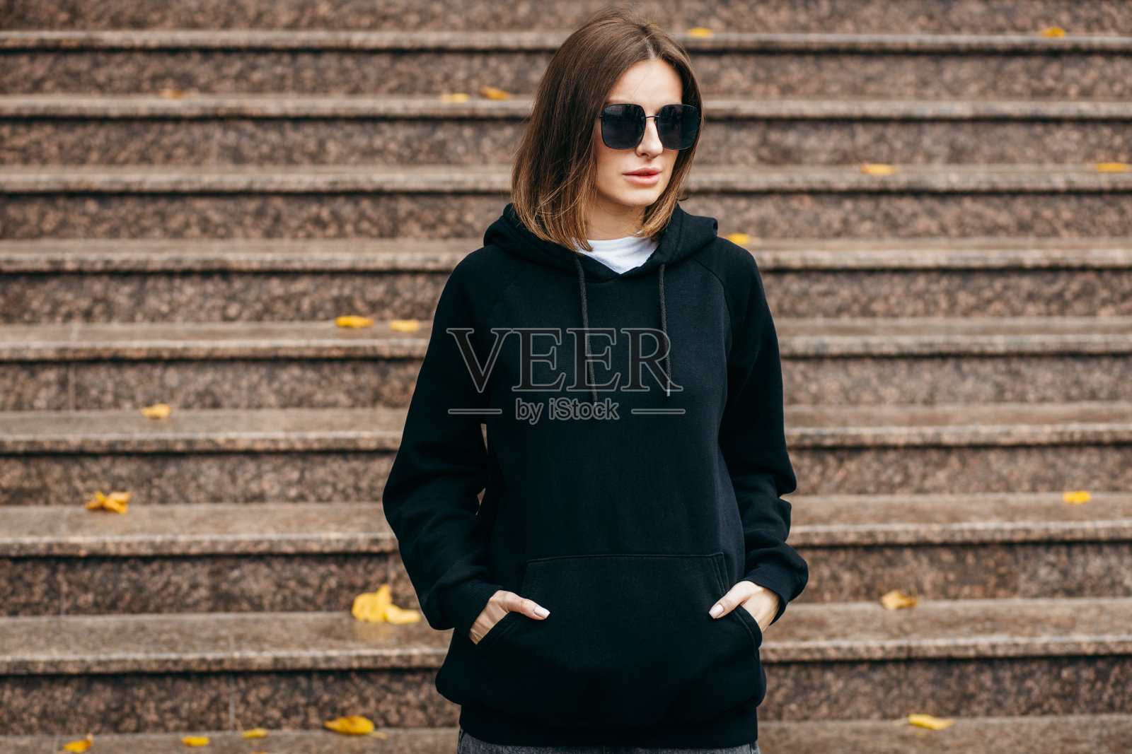 戴眼镜，穿黑色卫衣的年轻女子照片摄影图片