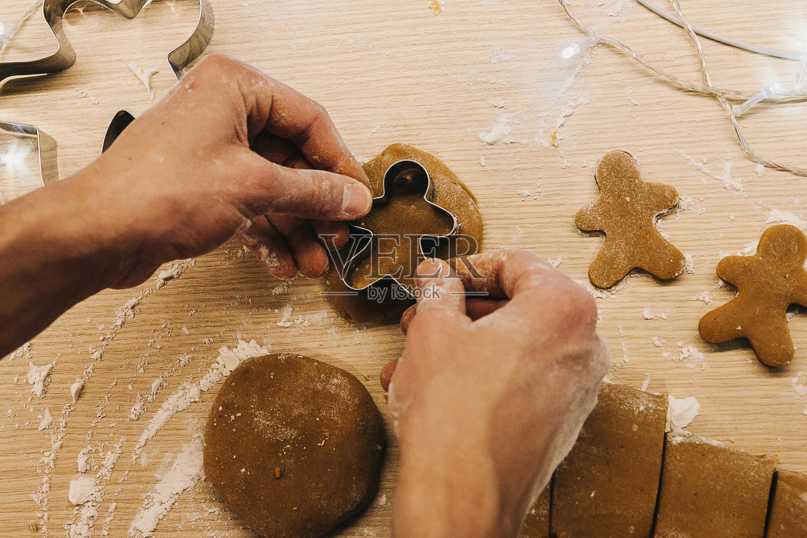 男人的手正在准备姜饼。姜的男人。照片摄影图片