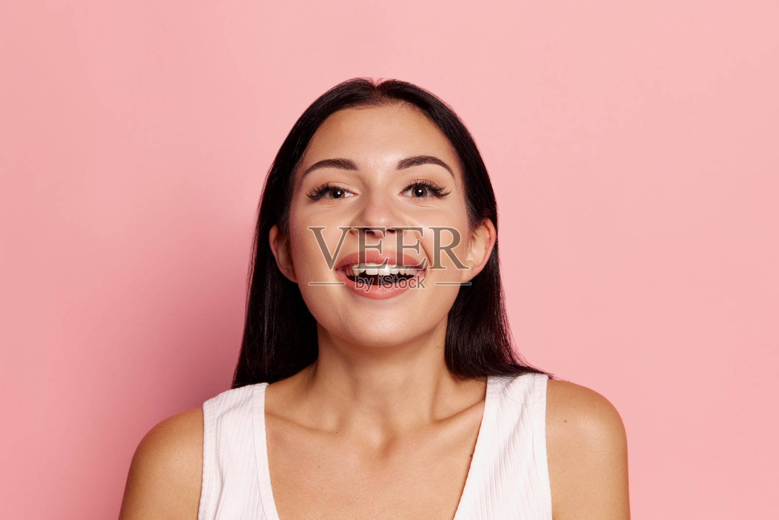 惊喜。获得成功的快乐女人庆祝成为赢家。白人女模特的形象在粉红色的工作室背景。胜利，喜悦的概念。人类面部表情的概念。照片摄影图片