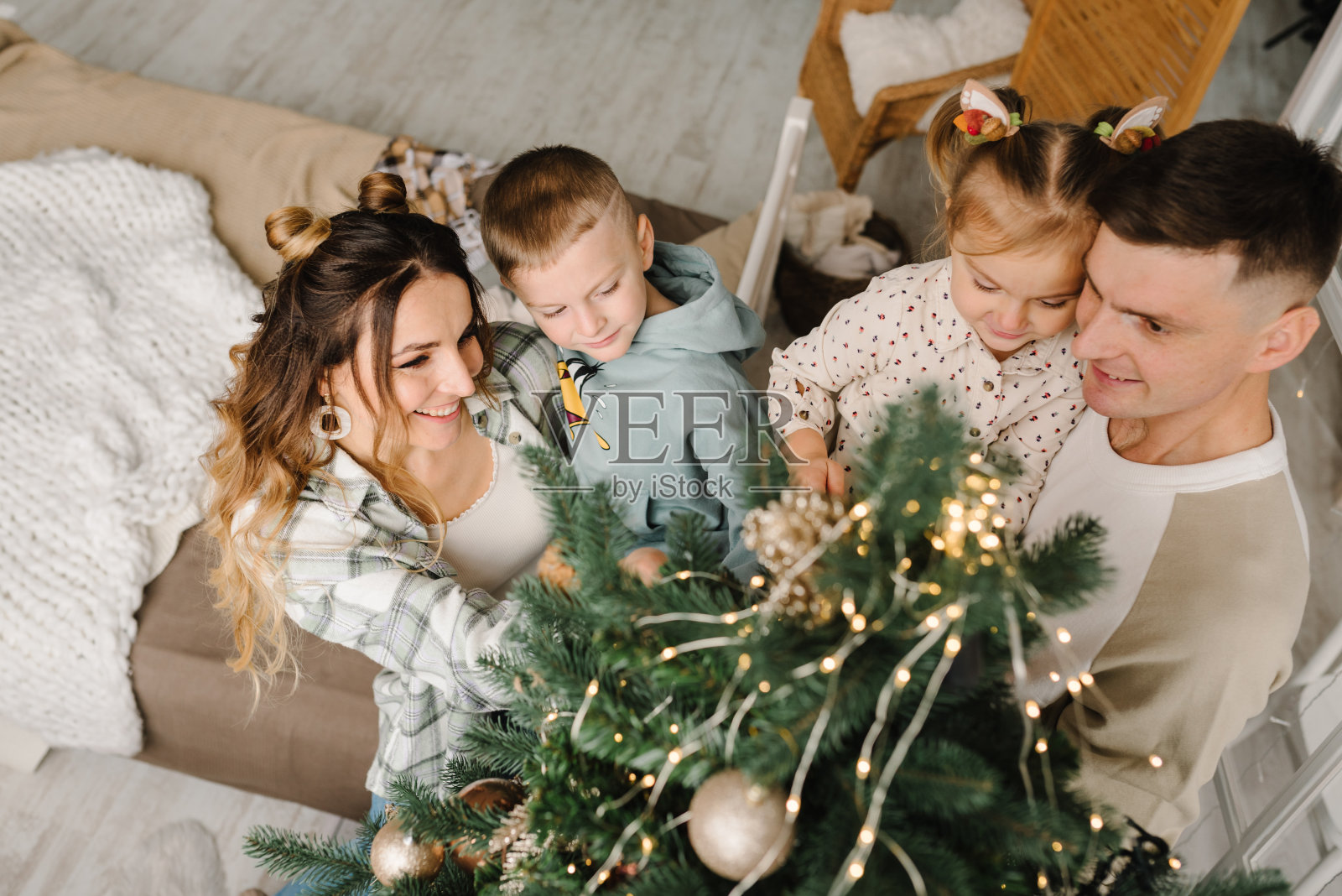 全家一起用玩具球装饰圣诞树照片摄影图片