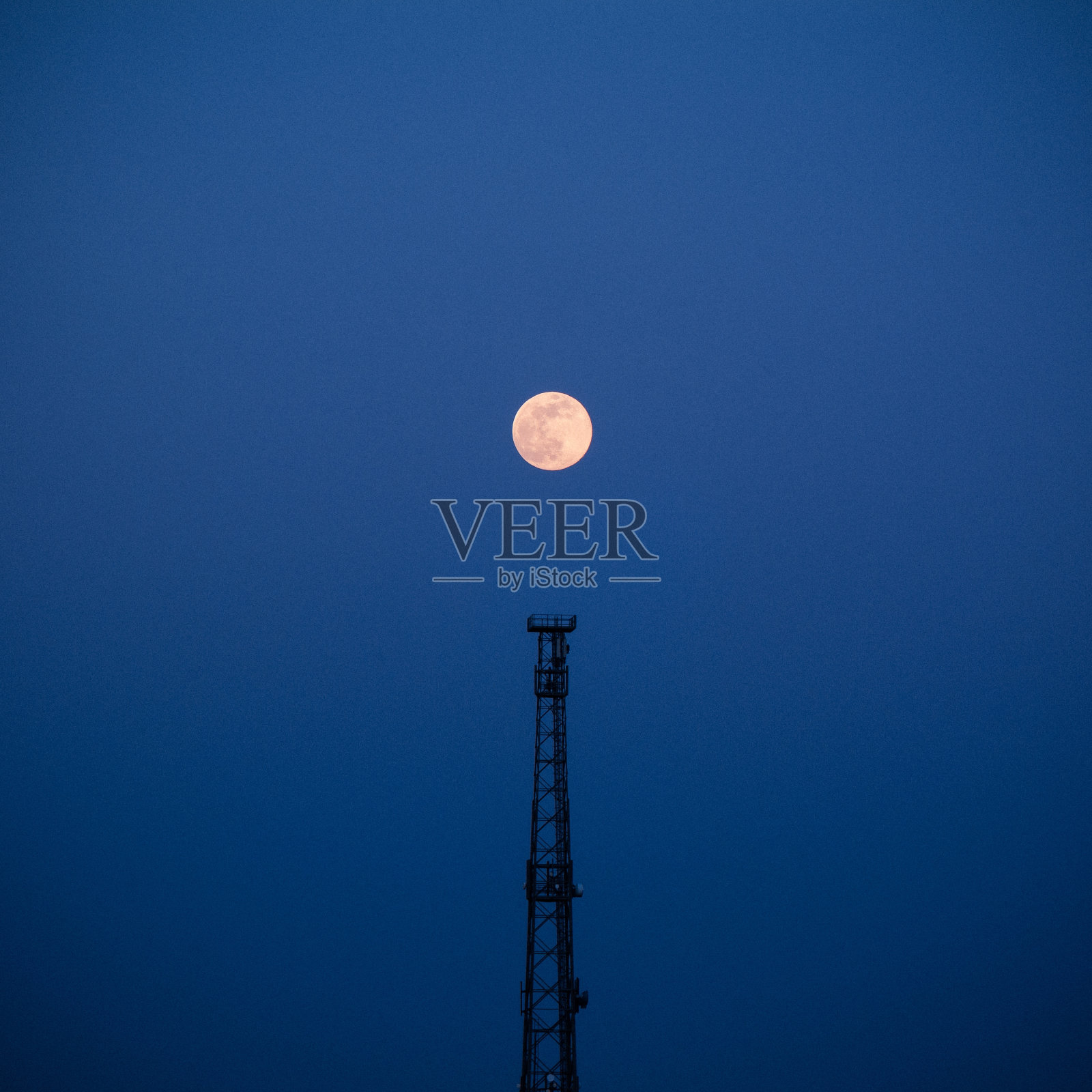 晚上的蓝天上，塔上的满月——非常适合做墙纸和背景照片摄影图片