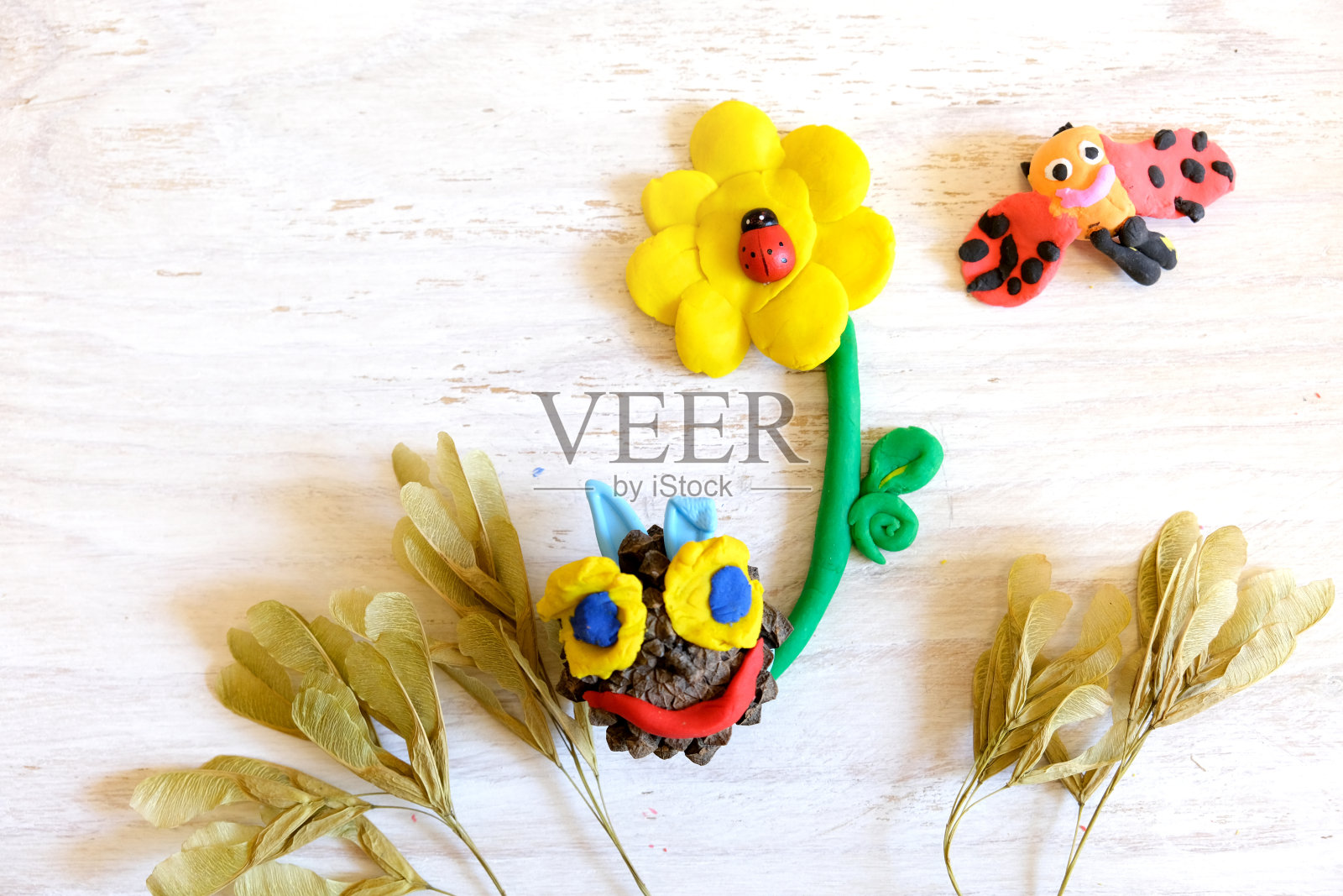 家庭教育游戏用黏土和自然材料，花和瓢虫由彩色橡皮泥，早期开发概念。有孩子的教育和娱乐课程照片摄影图片