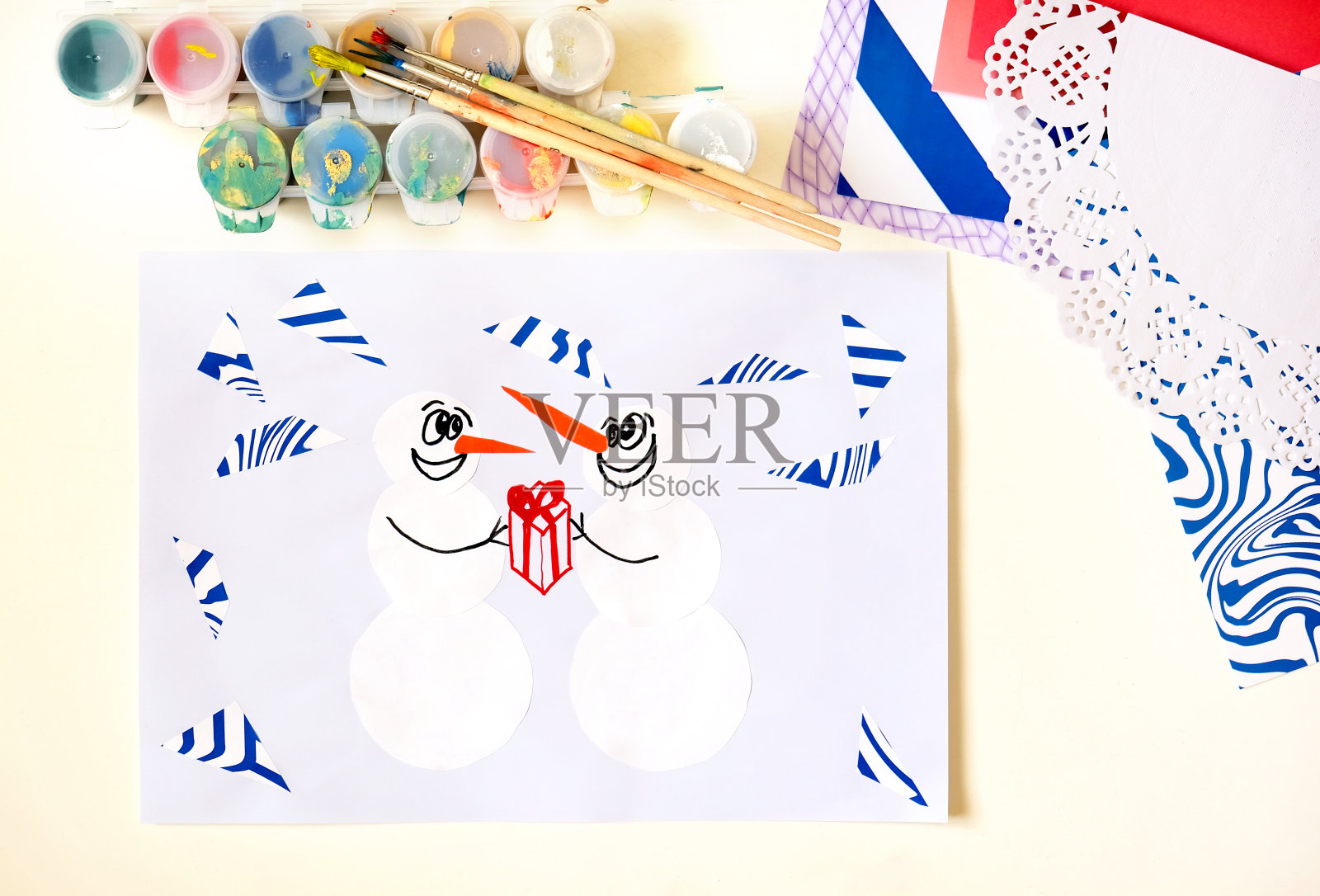 孩子用有趣的雪人制作贺卡。为儿童准备的圣诞工艺品。幼稚的艺术品。儿童创造力项目插画图片素材