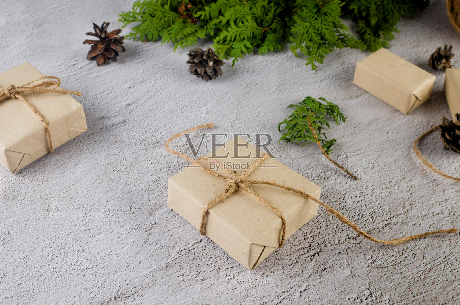 圣诞静物画。用牛皮纸包装的圣诞礼物，上面有松果、杉树树枝照片摄影图片