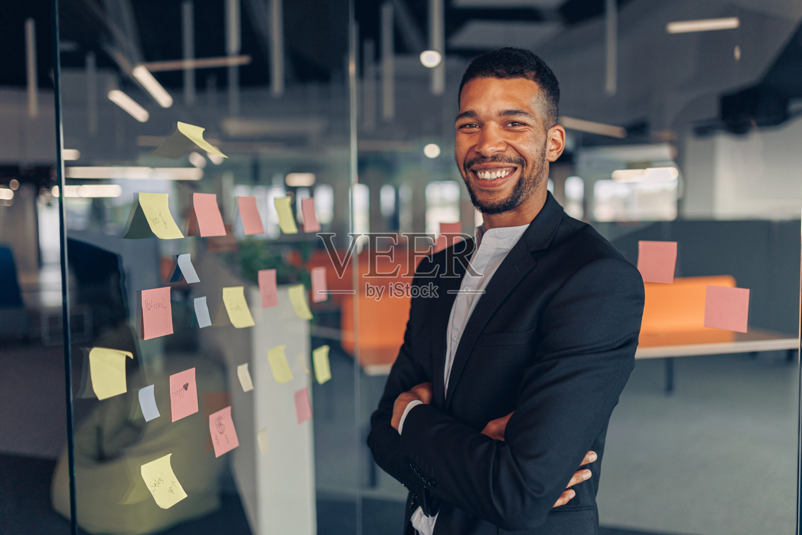 微笑的非洲商人站在办公室双手交叉的肖像照片摄影图片