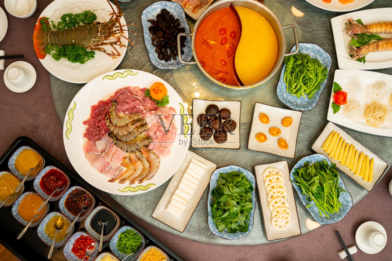 高角拍摄的菜肴与香料和酱料在一个东方圆桌照片摄影图片