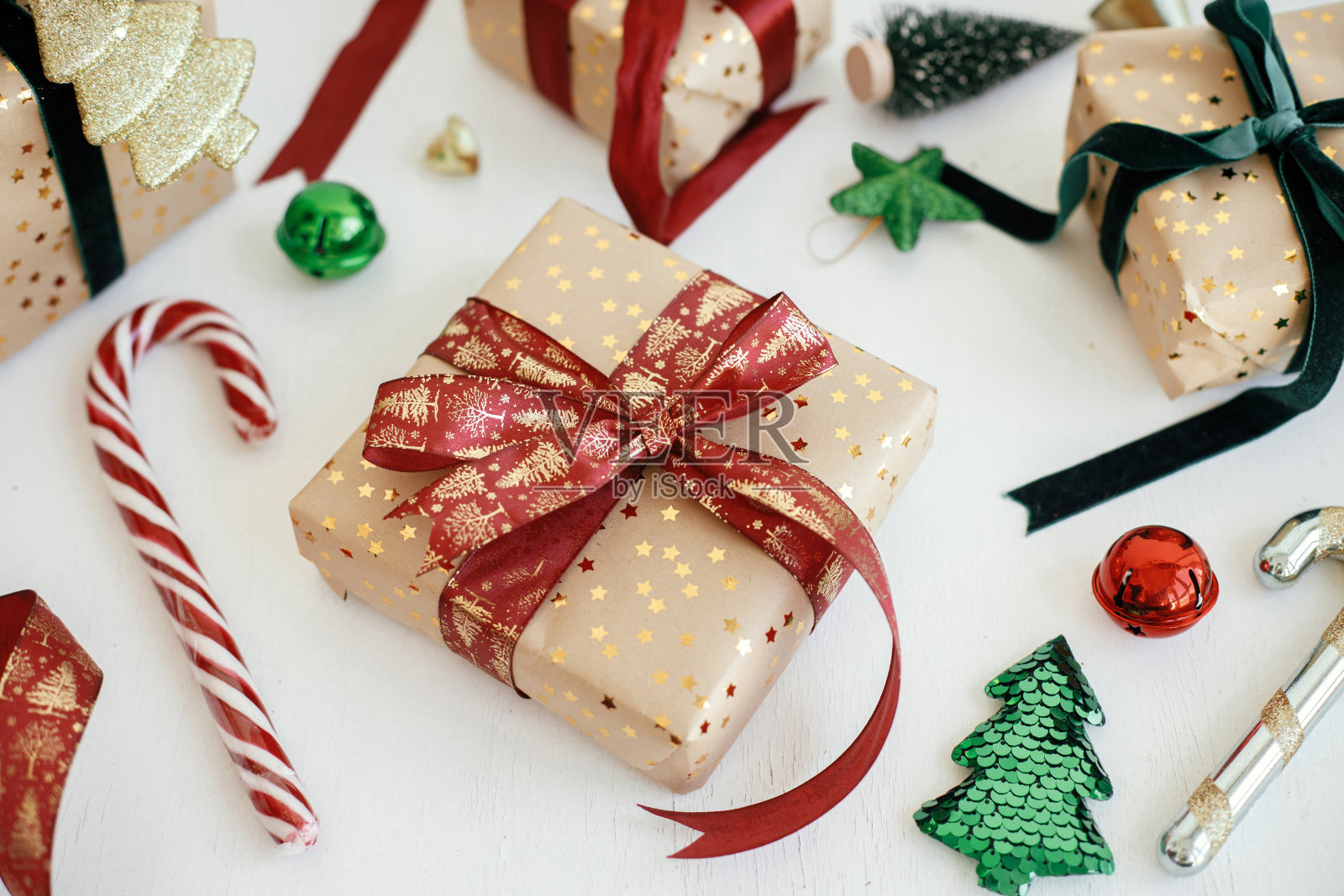 时髦的圣诞礼物。现代包装的圣诞礼盒，金色的纸，红色和绿色的丝带，装饰组成的白色木材。圣诞快乐，节日快乐!节日的旗帜照片摄影图片