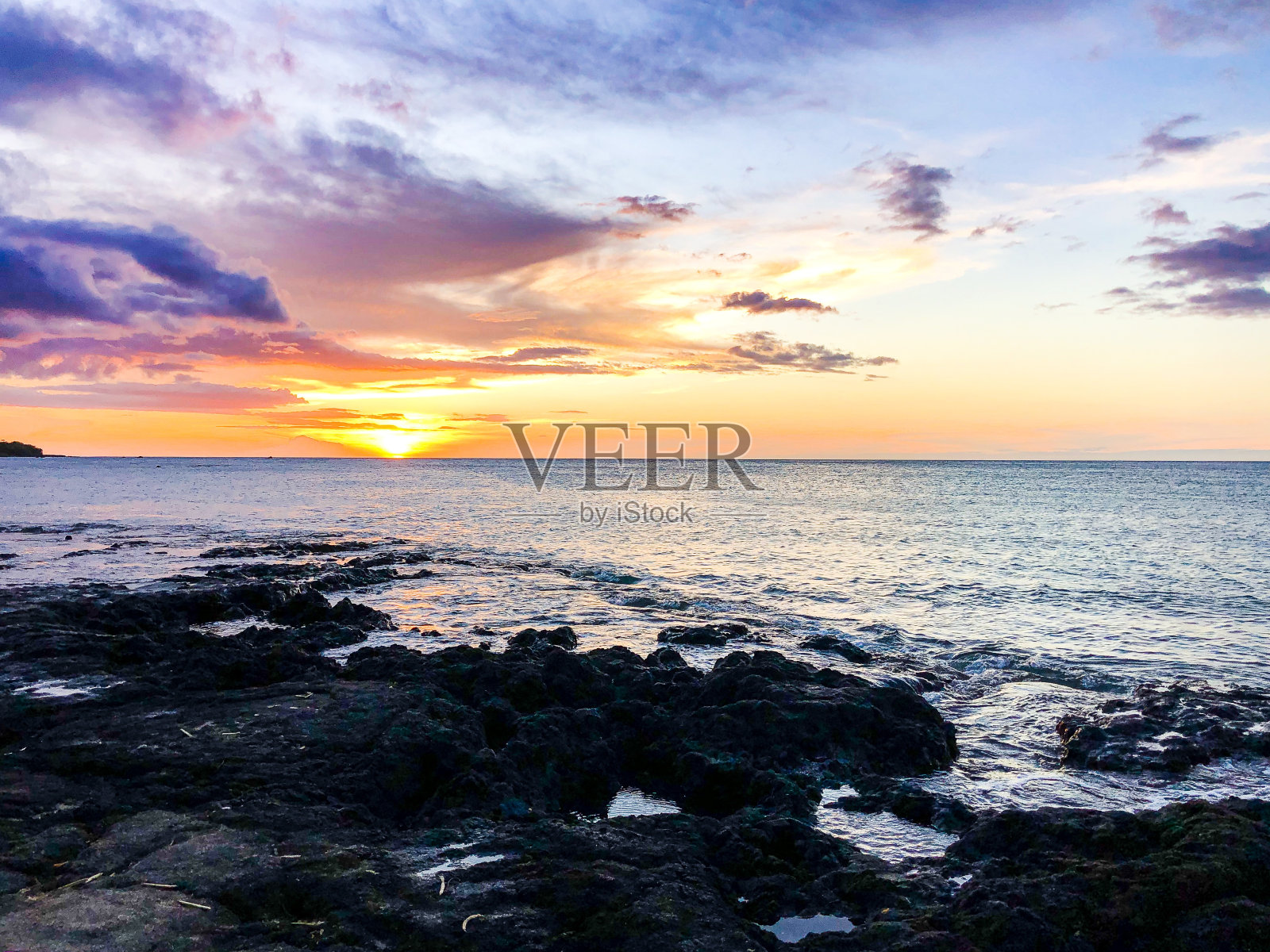 湛蓝多云的天空下，海浪拍打岩石的美丽镜头照片摄影图片