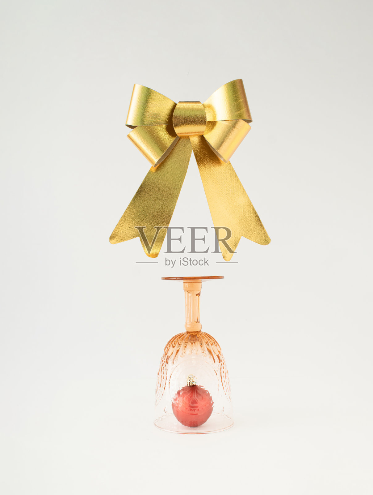 圣诞小玩意儿在老式的酒杯和金色丝带在白色的背景。简约的新年理念。照片摄影图片