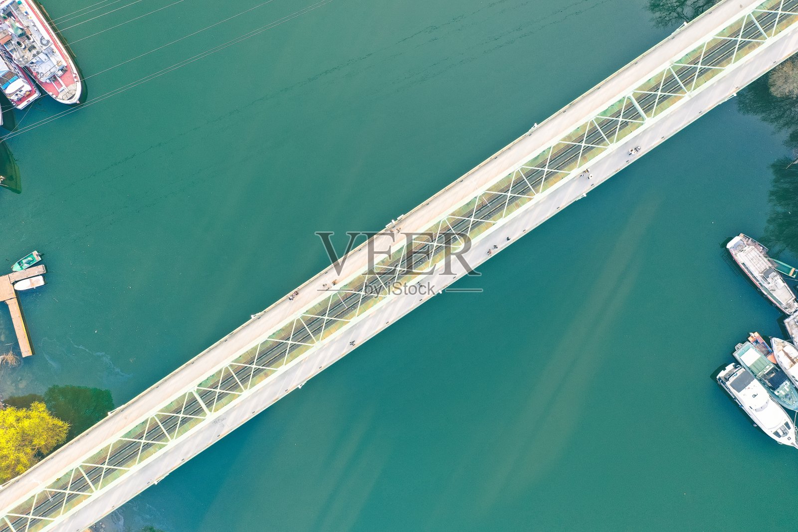 在大河上的狭长的桥，船停泊在岸边照片摄影图片