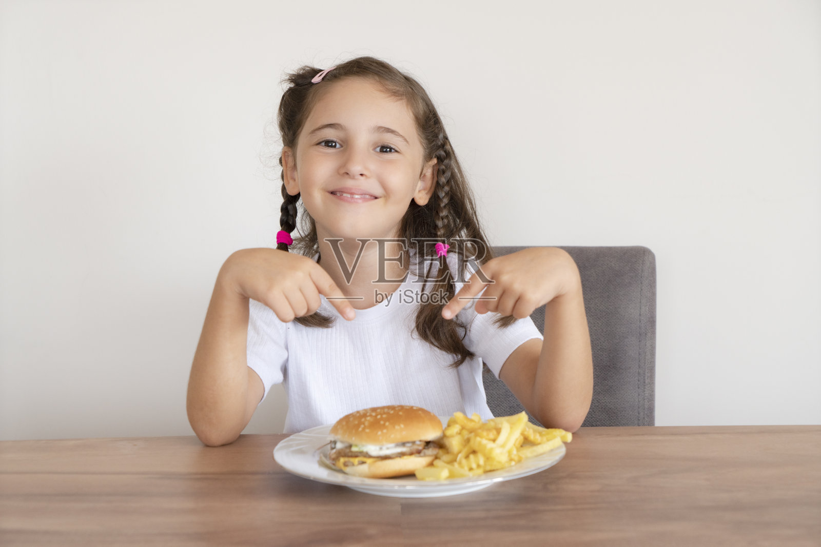 小女孩吃着一个大汉堡照片摄影图片