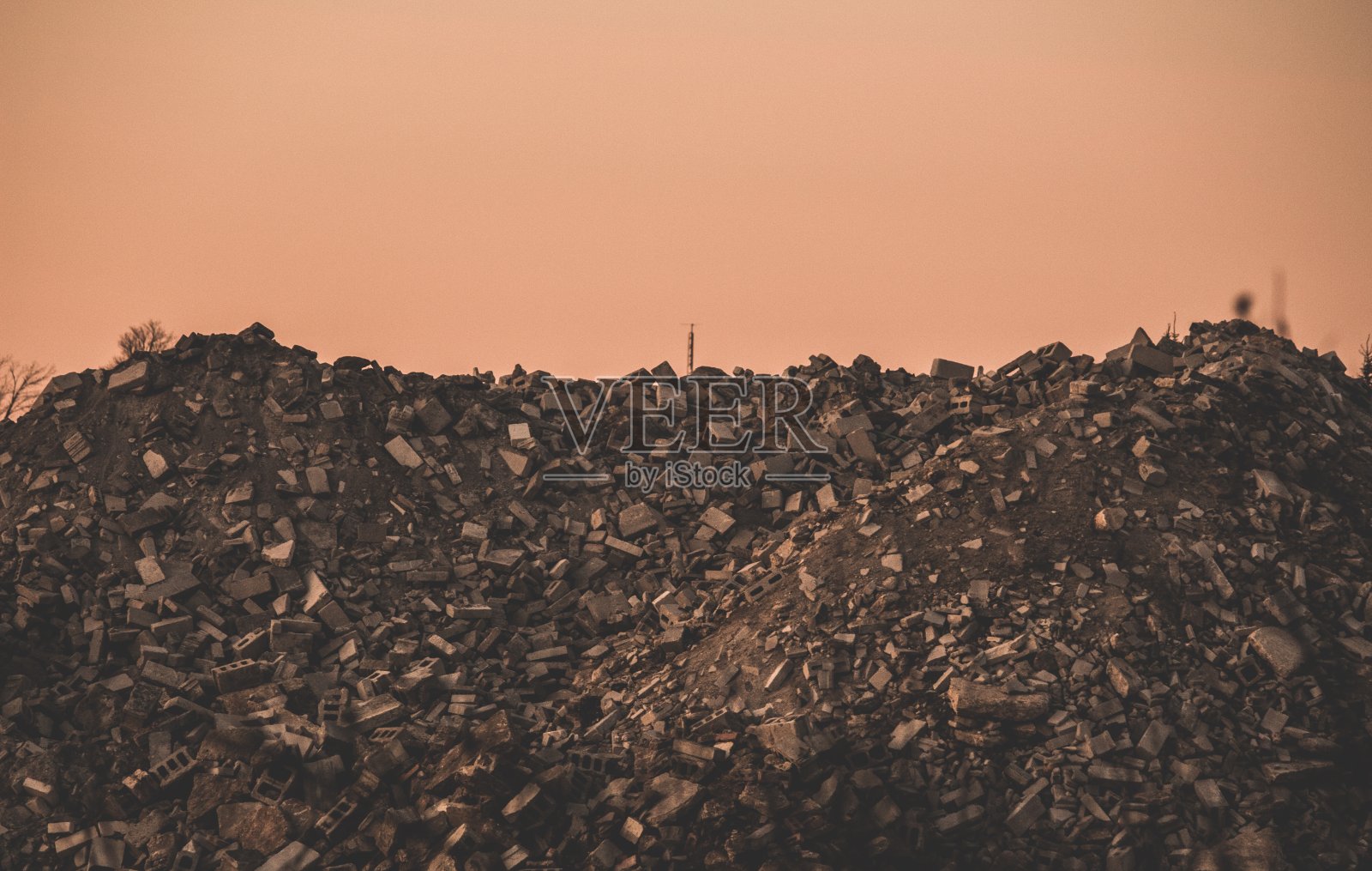 深色拍摄的工业垃圾场在岩石与粉红色的背景照片摄影图片