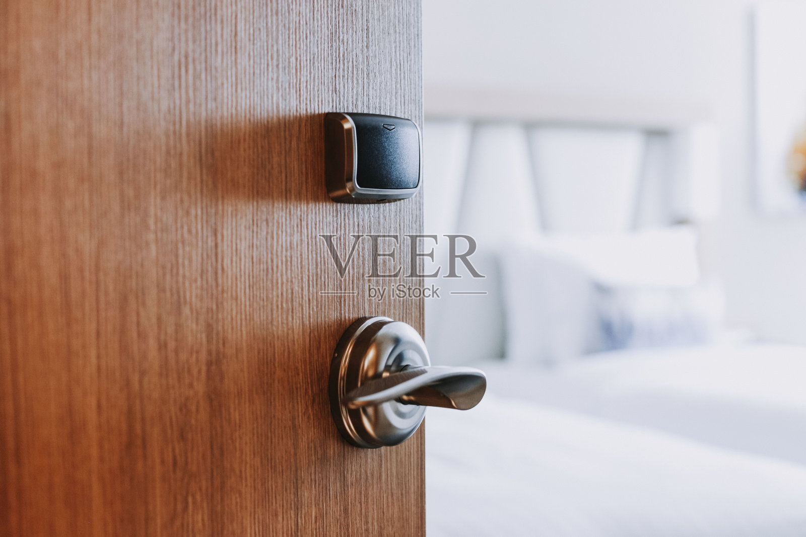 一扇打开的木门通向一间白色极简风格的卧室照片摄影图片