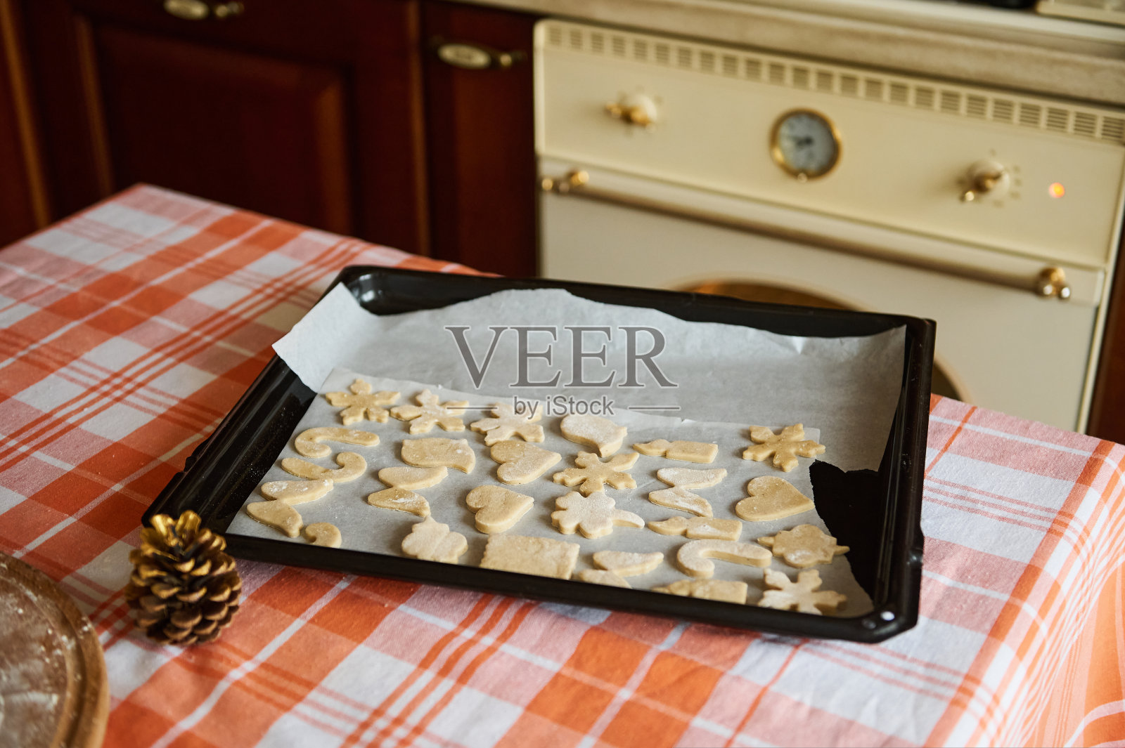 在烤盘上雕刻出心形、蜡烛、拐杖糖、鸟、天使翅膀和雪花的姜饼饼干照片摄影图片