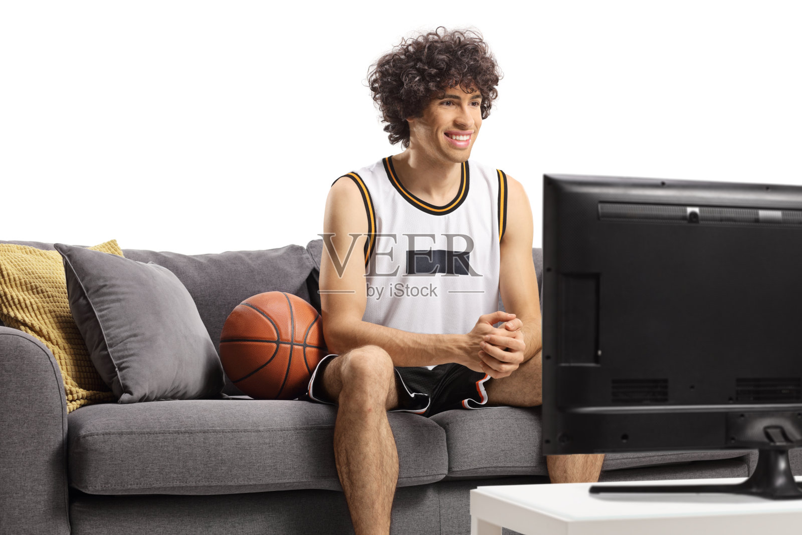 一个篮球运动员坐在沙发上看电视照片摄影图片