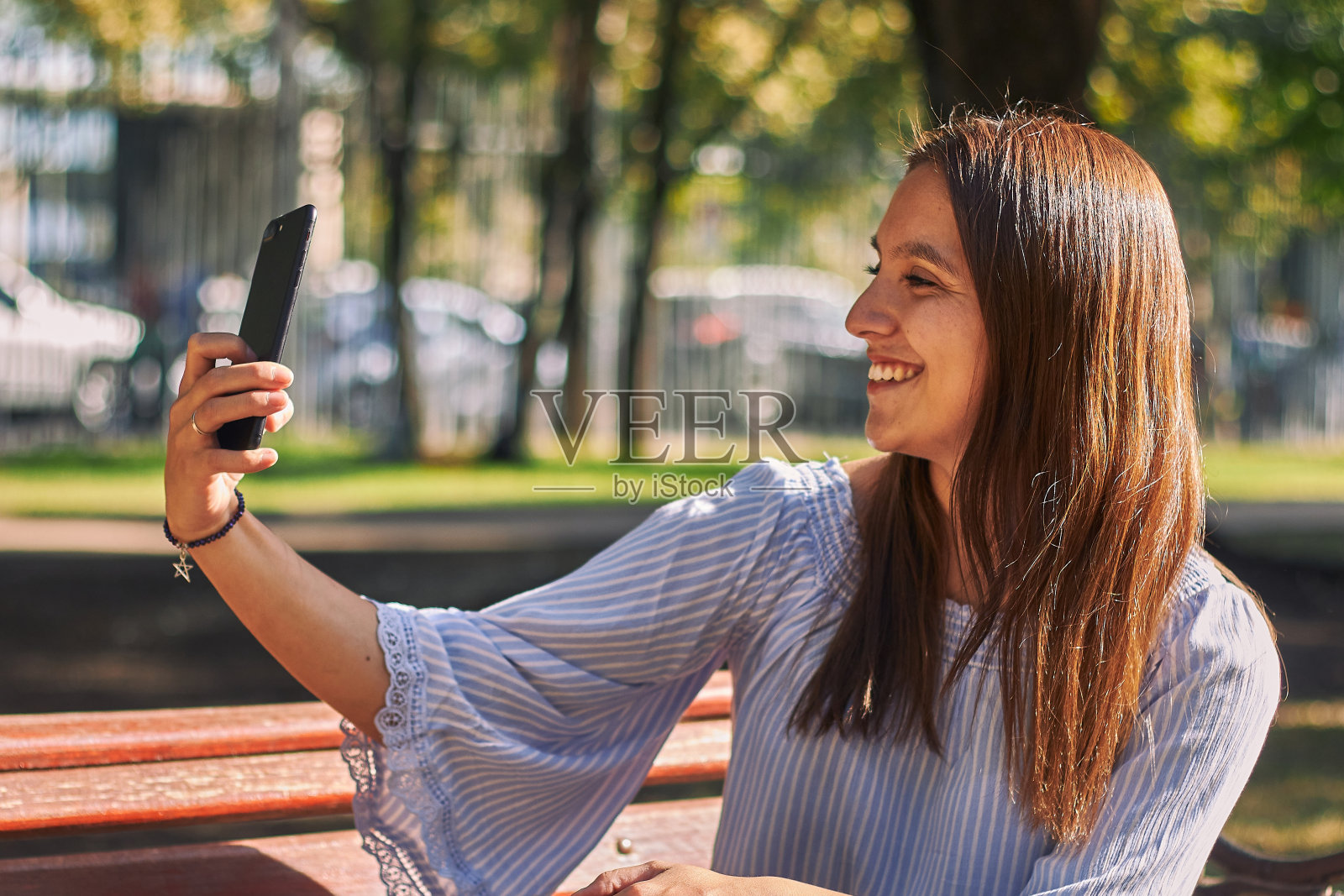 一个穿蓝色衬衫的女孩在自拍照片摄影图片