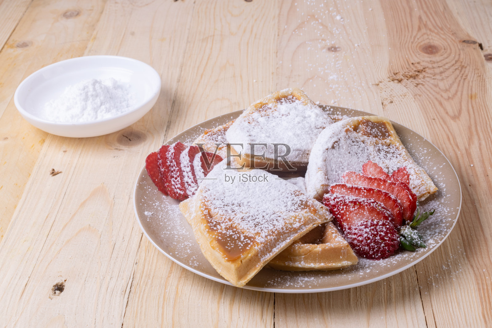 特写切片华夫饼与新鲜草莓和撒糖粉照片摄影图片