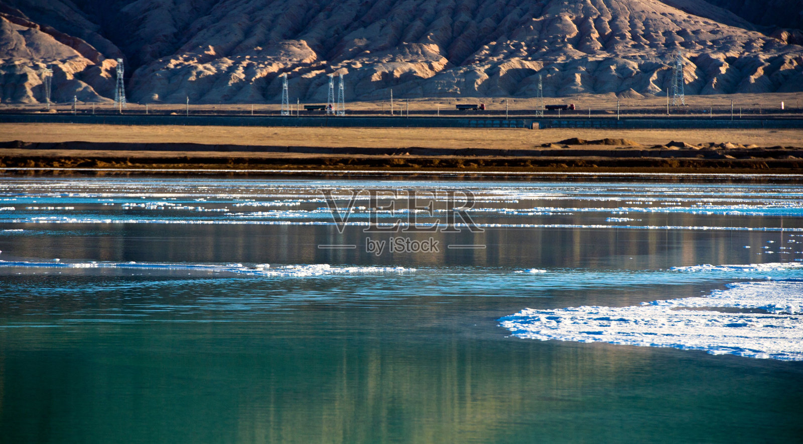 结冰的水和远处的山的美丽景色。照片摄影图片