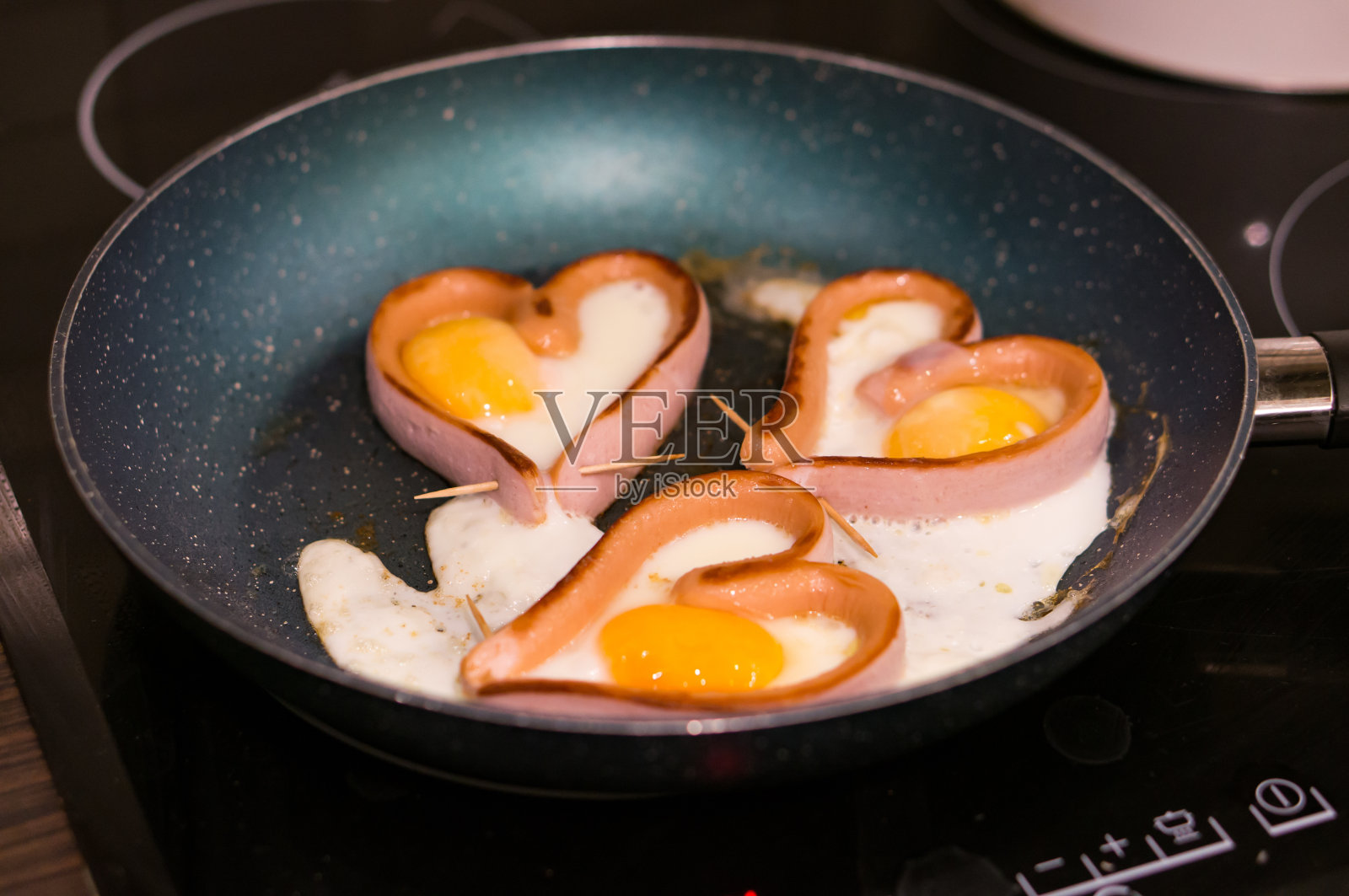 心形香肠和煎锅里的鸡蛋特写镜头照片摄影图片