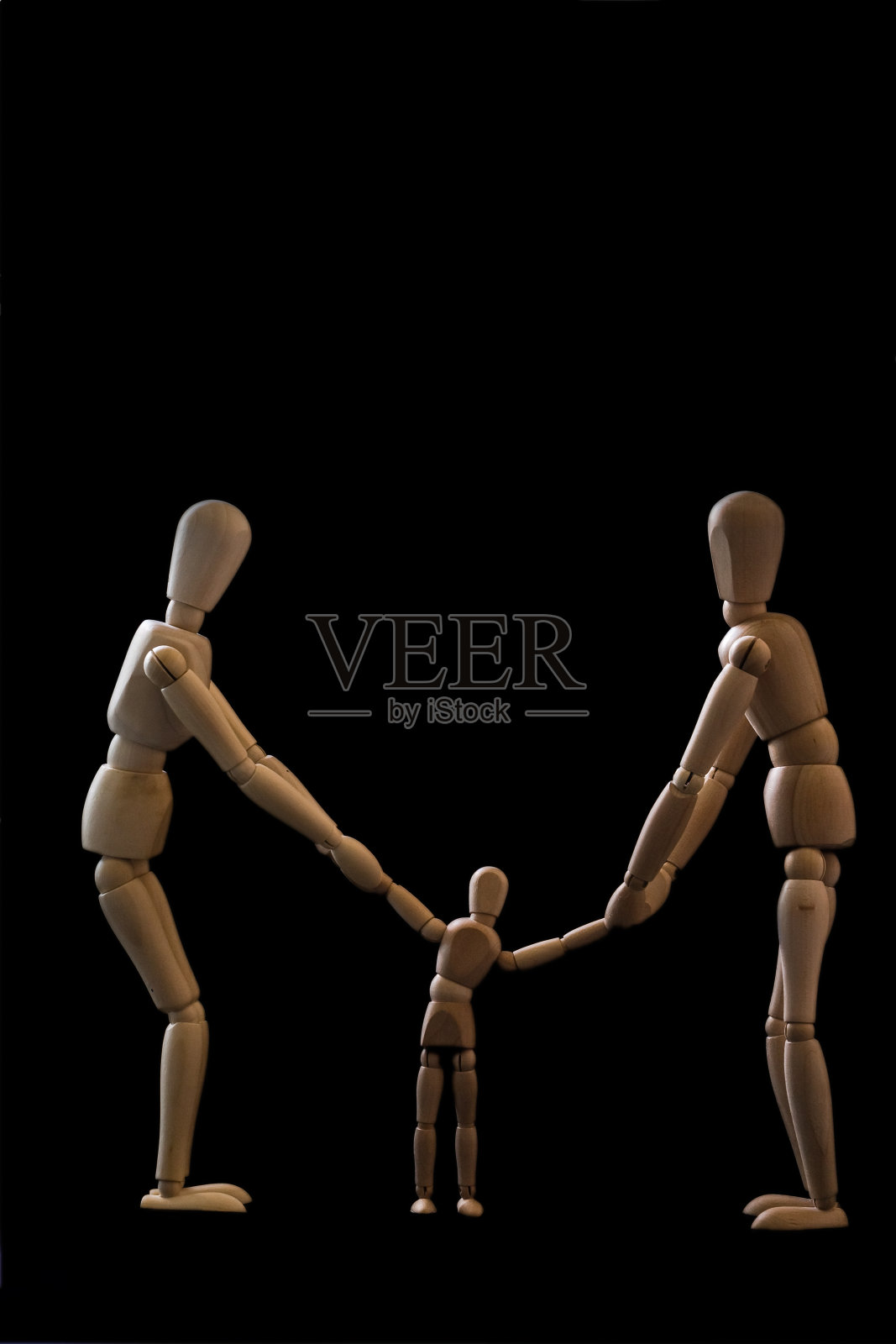 垂直拍摄的木制假人家庭孤立在一个黑色背景-离婚的概念照片摄影图片