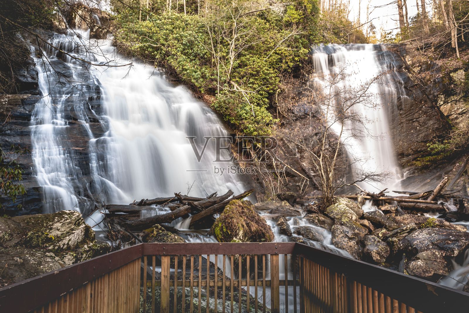 从木桥和岩石上看，在森林里，在瀑布上，与水的长曝光镜头照片摄影图片
