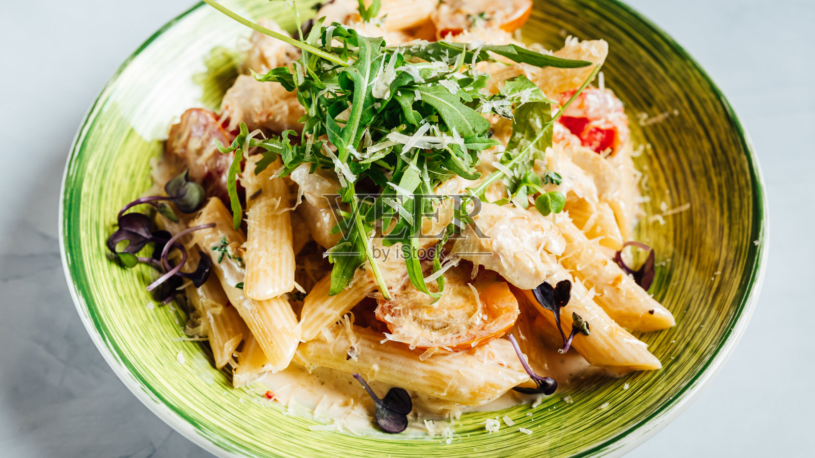 特写新鲜美味的意大利面与碎奶酪和芝麻菜在盘子上照片摄影图片