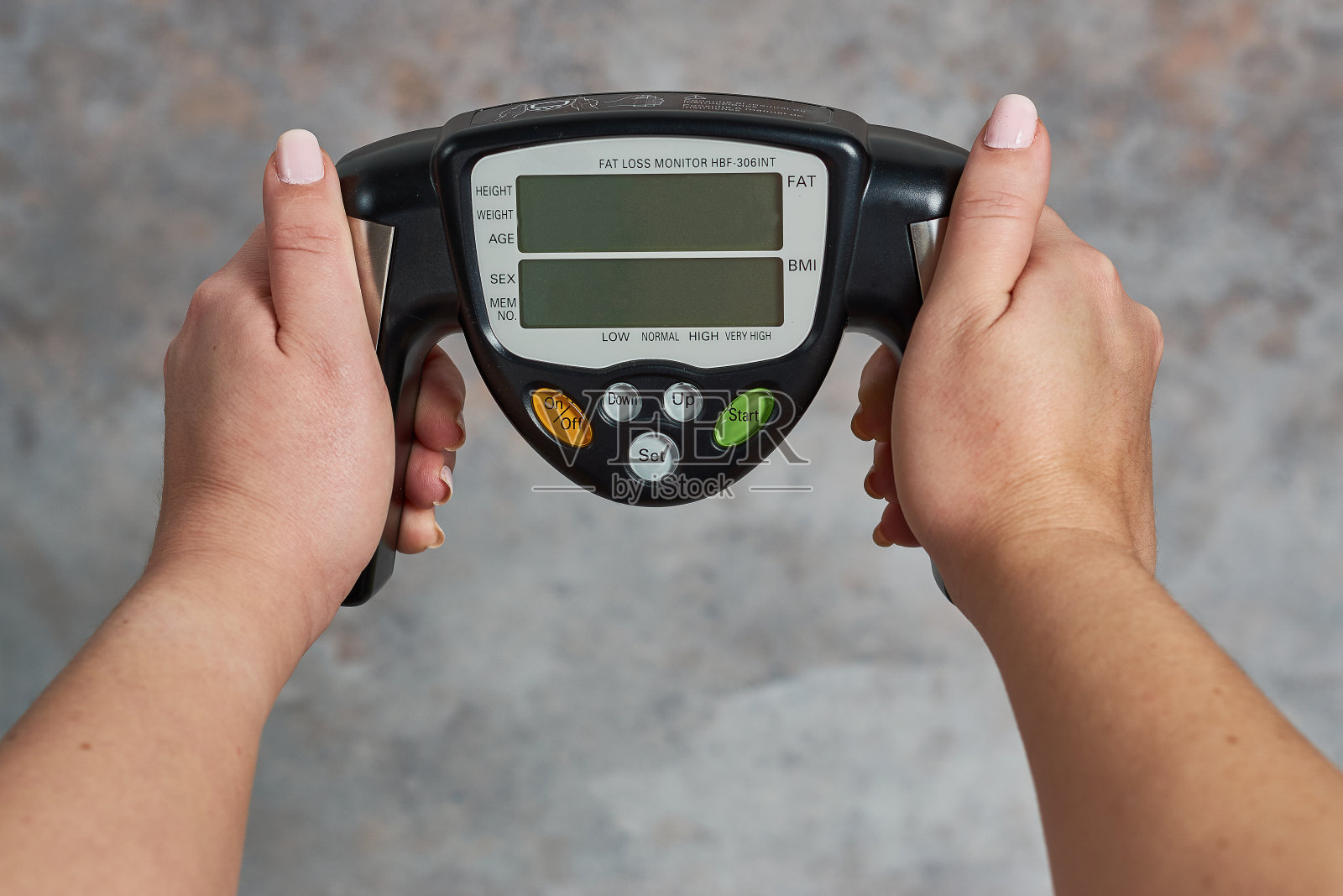 拿着减脂监测器的女性背景很邋遢照片摄影图片