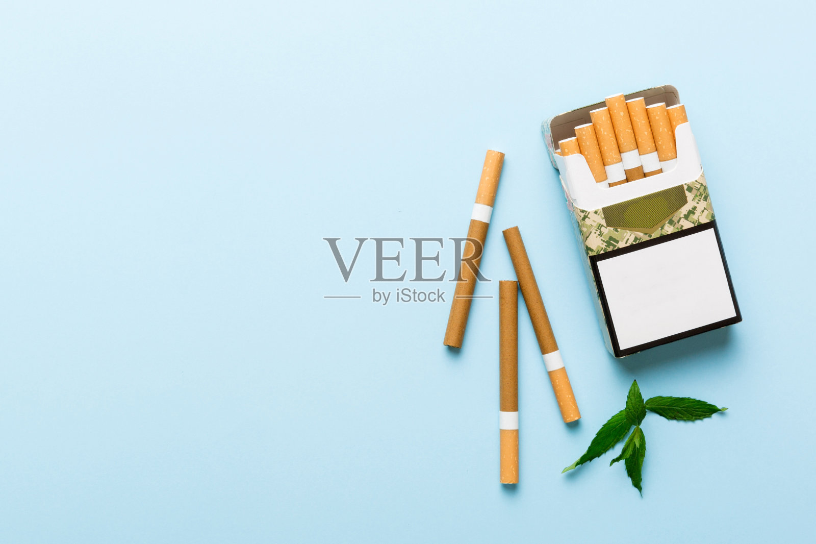 包装薄荷香烟和新鲜薄荷在彩色桌子上，薄荷香烟顶部视图平躺照片摄影图片