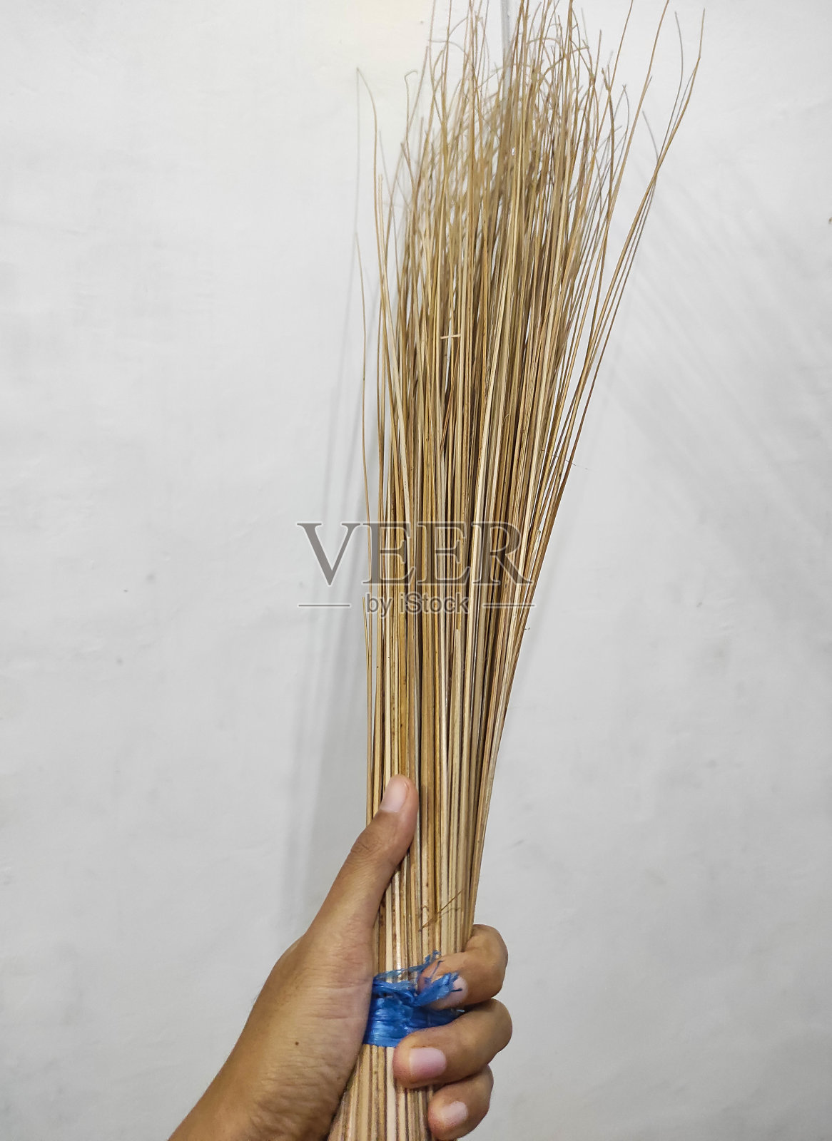 手拿椰子扫帚棒或Sapu Lidi在印度尼西亚-股票照片。照片摄影图片