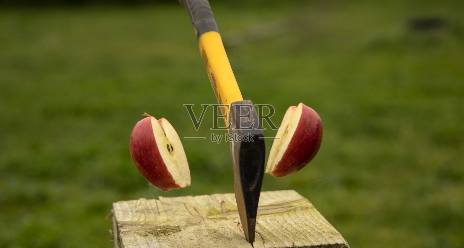 斧头把红苹果劈成两半的镜头照片摄影图片