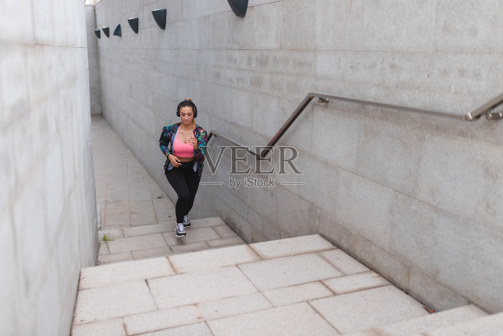 健身年轻女运动员在城市环境中跑步上楼梯照片摄影图片