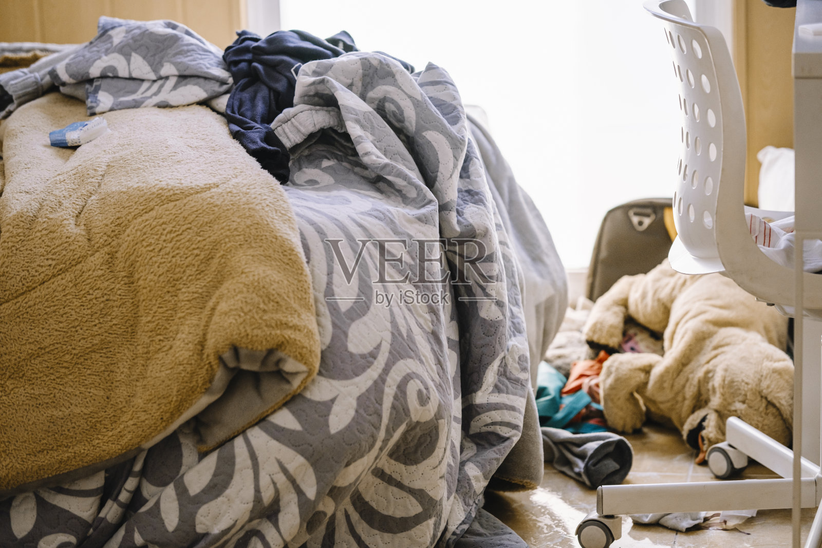 凌乱的青少年房间，衣服散落在地板上。照片摄影图片