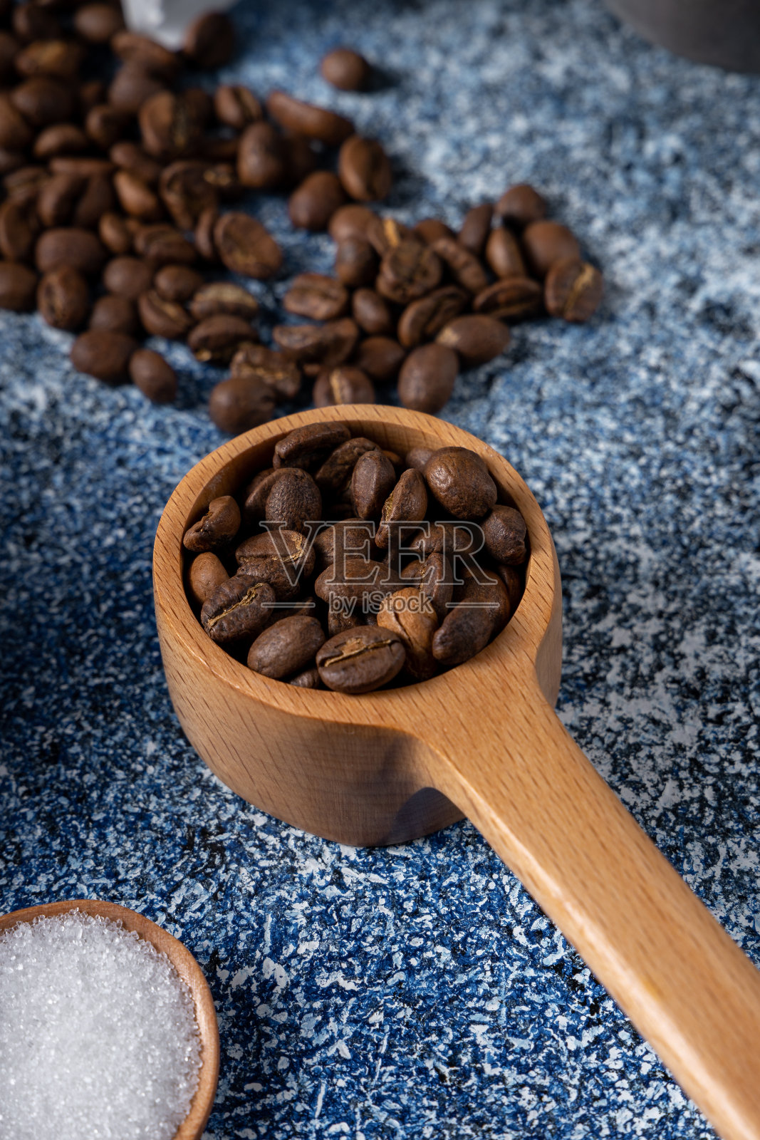 桌子上木勺里一堆咖啡豆的垂直镜头照片摄影图片