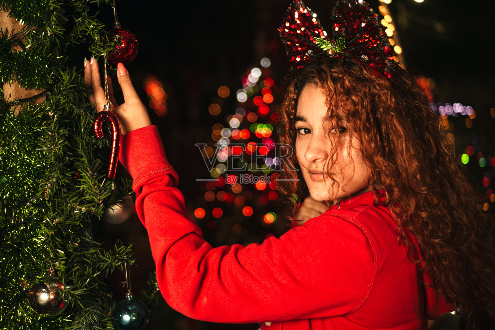 肖像的拉丁美洲妇女拿着一个圣诞球看着相机照片摄影图片