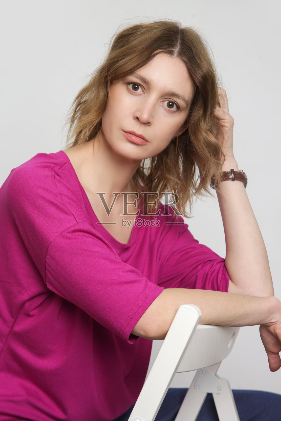 系列工作室照片的年轻女模特穿亮粉色棉蝙蝠翼衬衫照片摄影图片