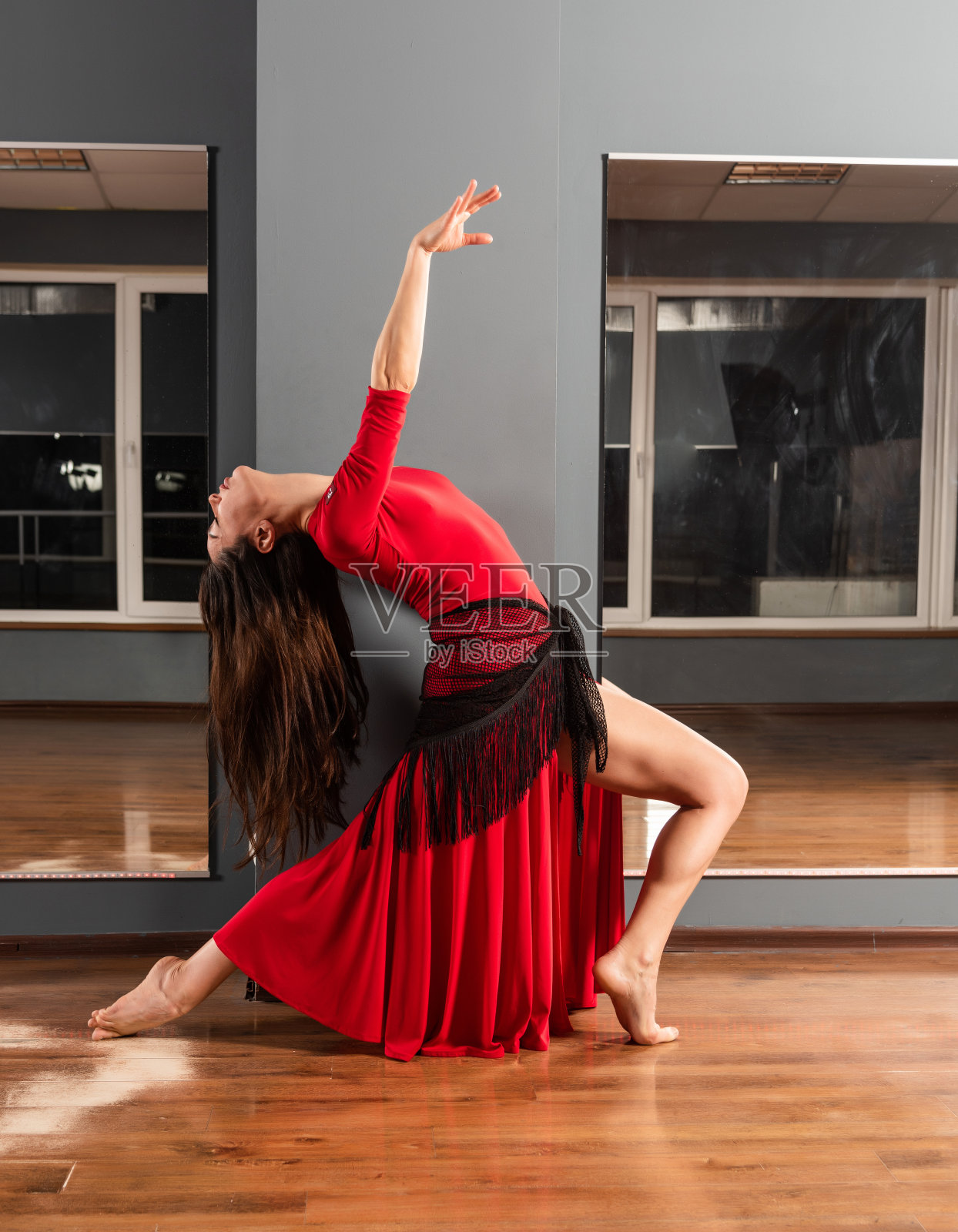 穿红衣服的女孩正在舞蹈室训练照片摄影图片