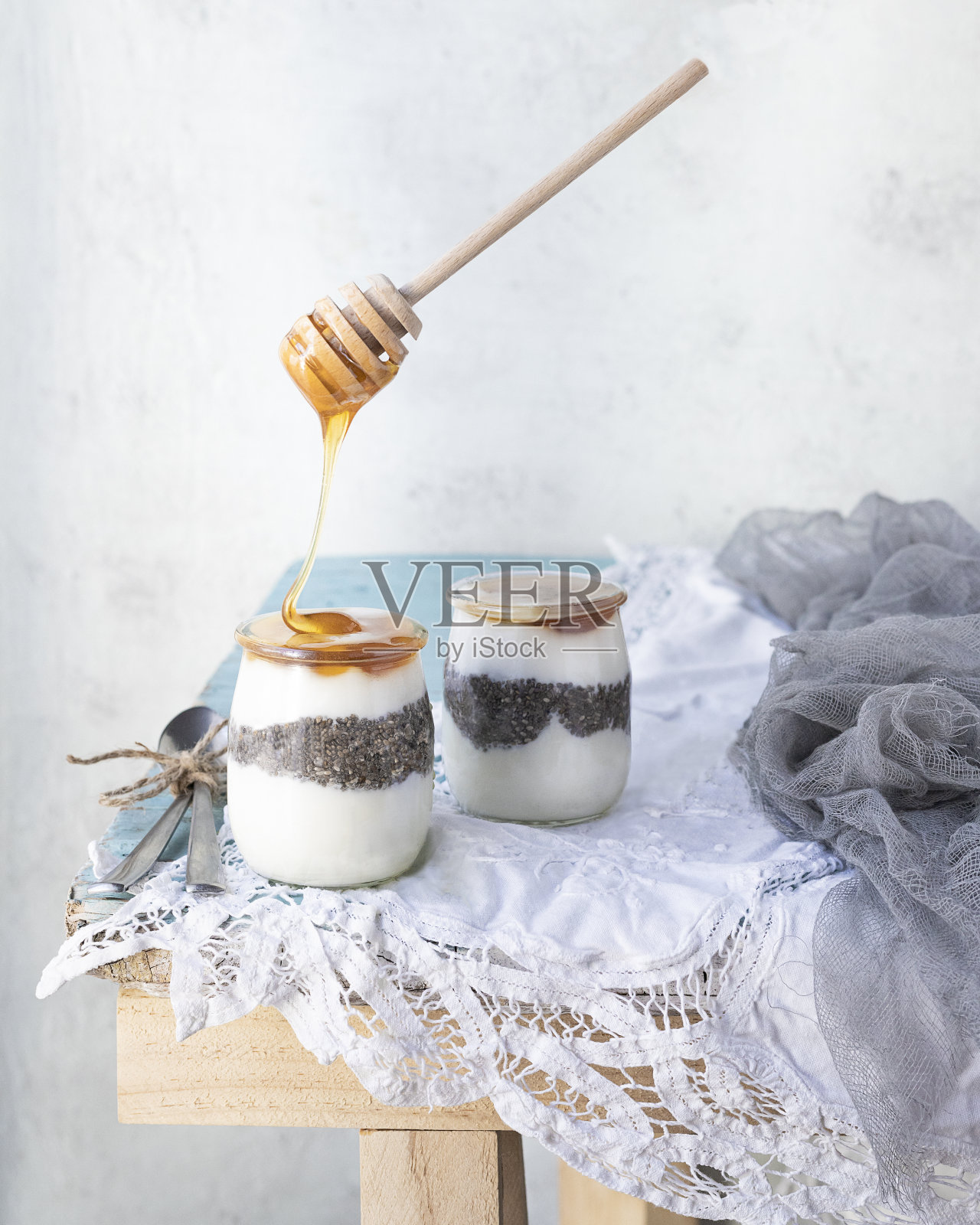 蜂蜜顺着桌子上的玻璃罐里的浮动勺流下的美丽镜头照片摄影图片