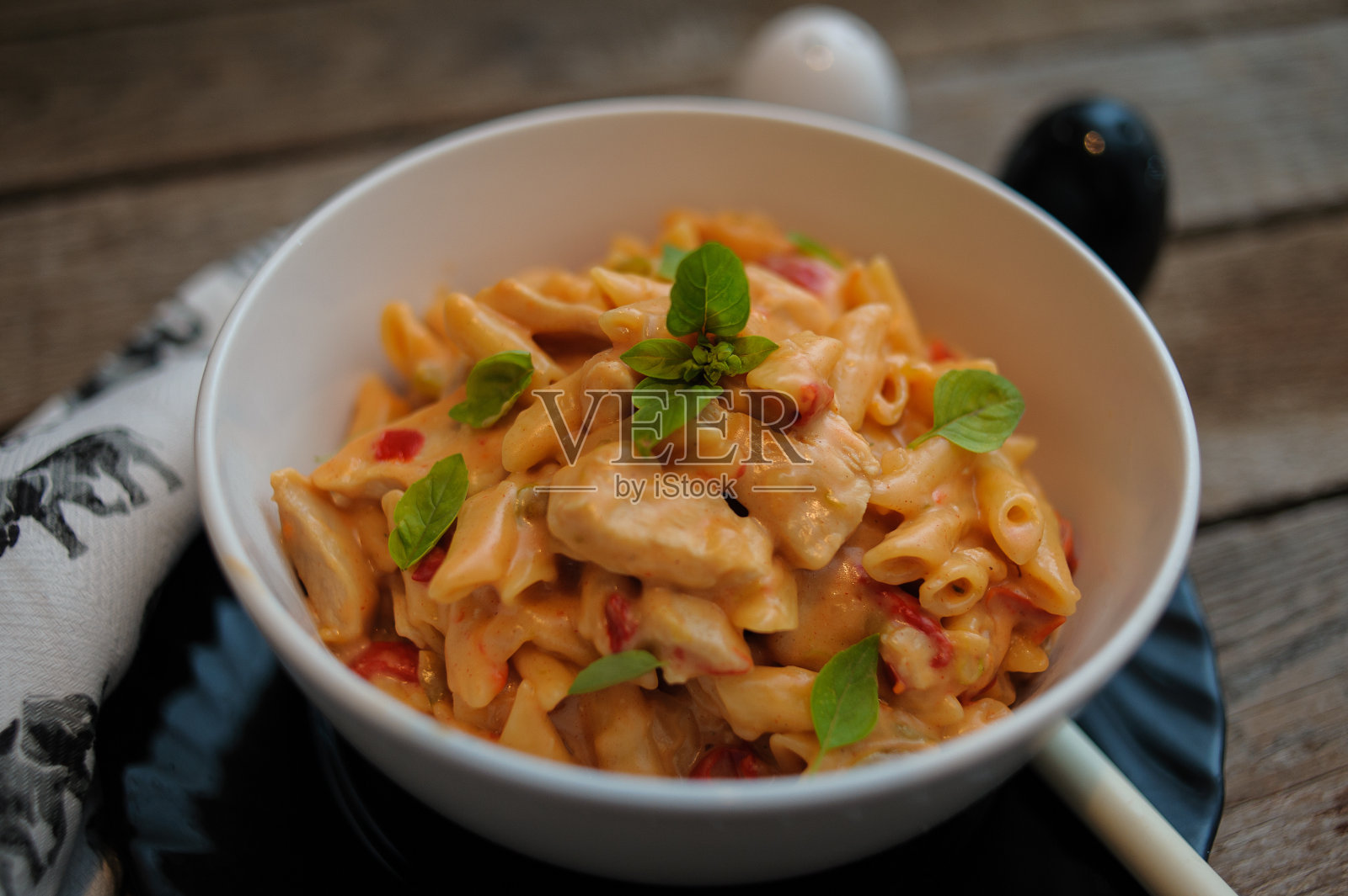 用奶酪和酱汁煮熟的意大利面，盛在一个白色的碗里照片摄影图片