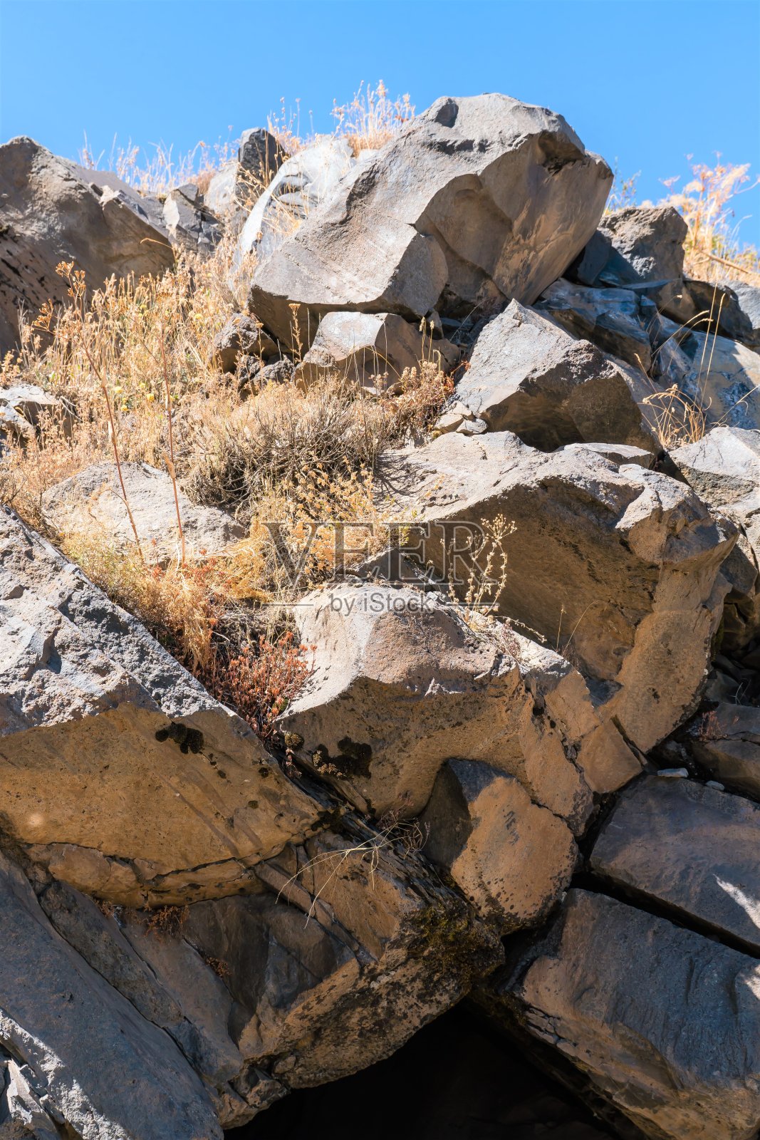 小龛在山腰的一块石头上，阳光明媚的日子。照片摄影图片
