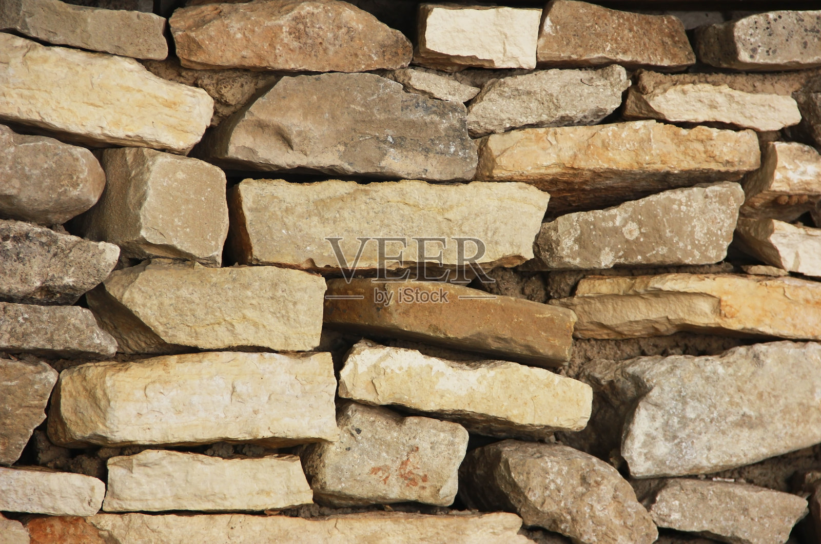 一堵由棕色花岗岩堆叠而成的墙的纹理照片摄影图片