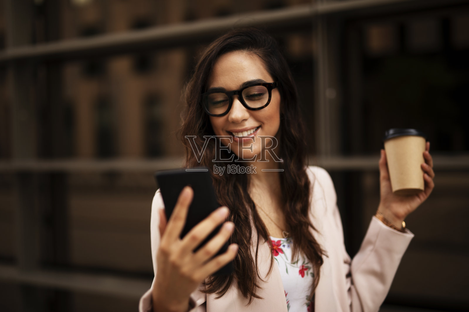 漂亮的女商人端着咖啡要走。照片摄影图片