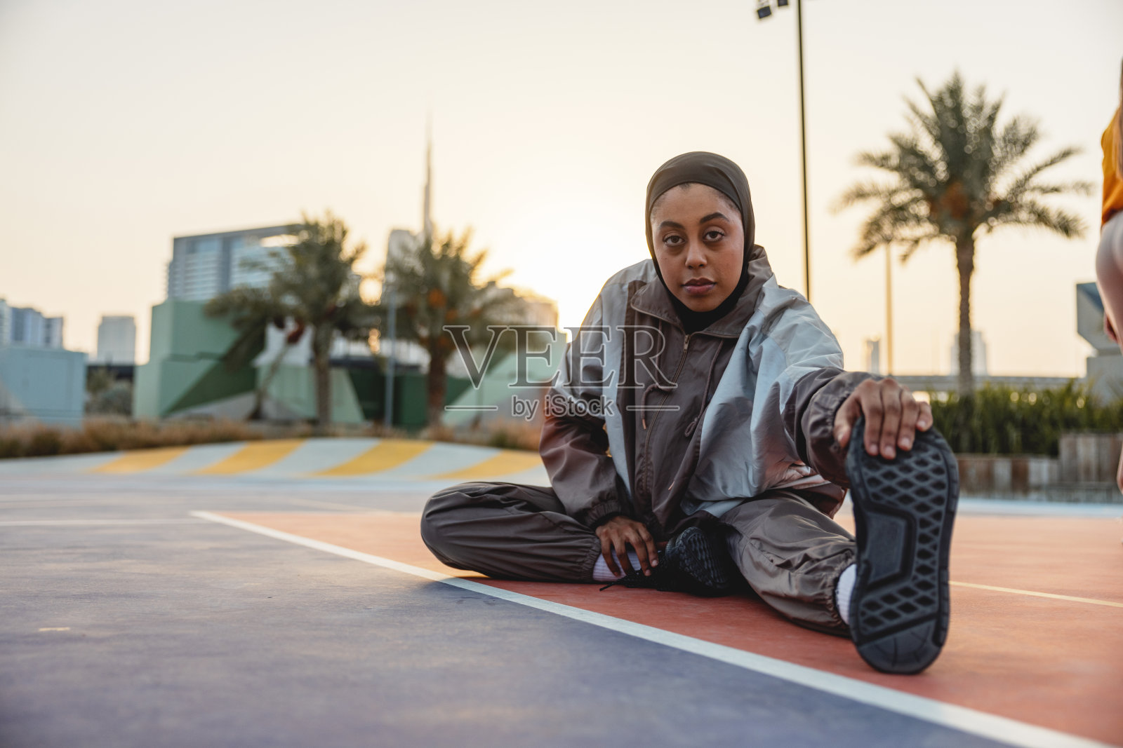迪拜日落时分户外伸展的阿拉伯年轻女子照片摄影图片