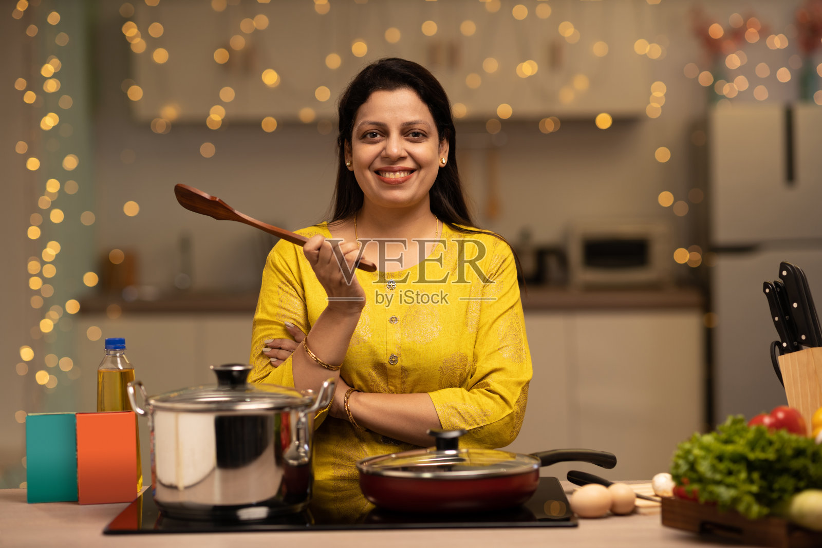 印度妇女在厨房做饭时享受的画像。库存图片照片摄影图片