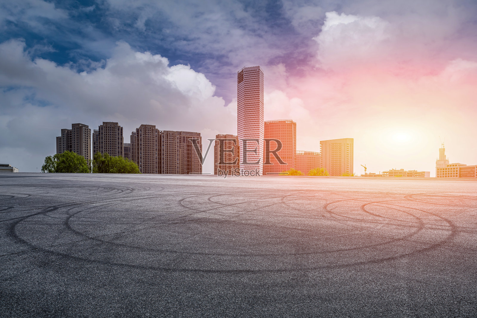 夕阳下的柏油跑道和城市建筑照片摄影图片
