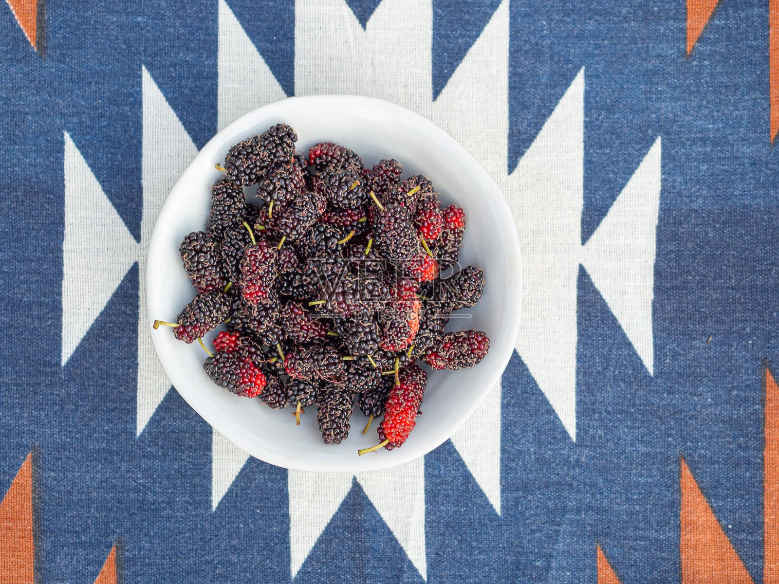 成熟的桑葚放在白色的盘子上照片摄影图片