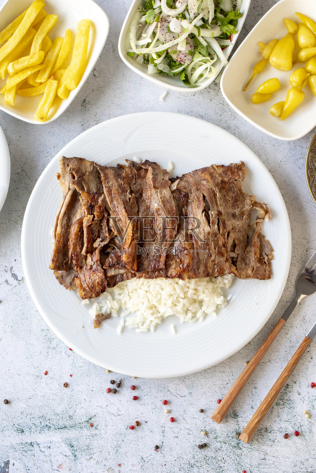 灰色背景上的米饭。传统的味道。用牛肉和羊肉做成的烤肉串。俯视图照片摄影图片