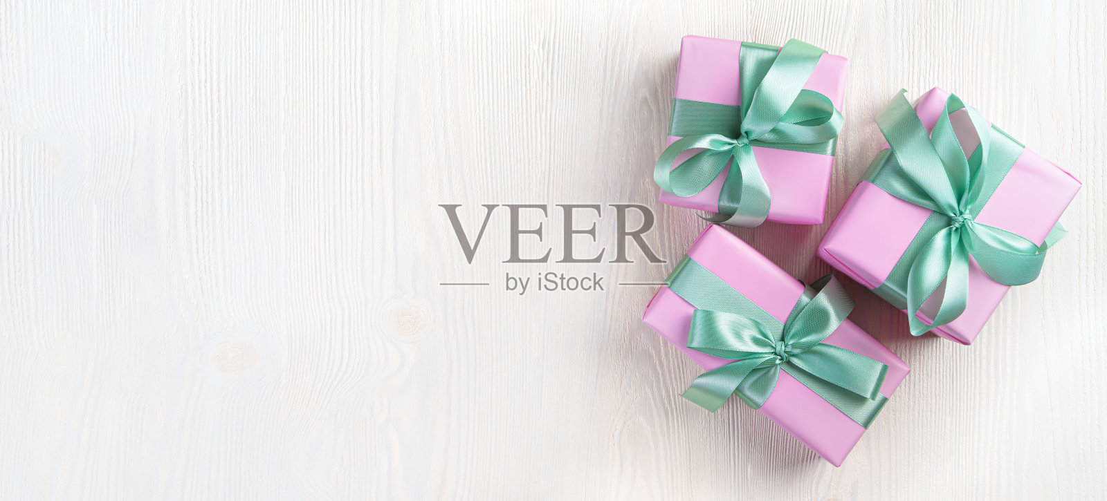 三个粉红色的礼品盒在一个明亮的背景。假期的概念。照片摄影图片